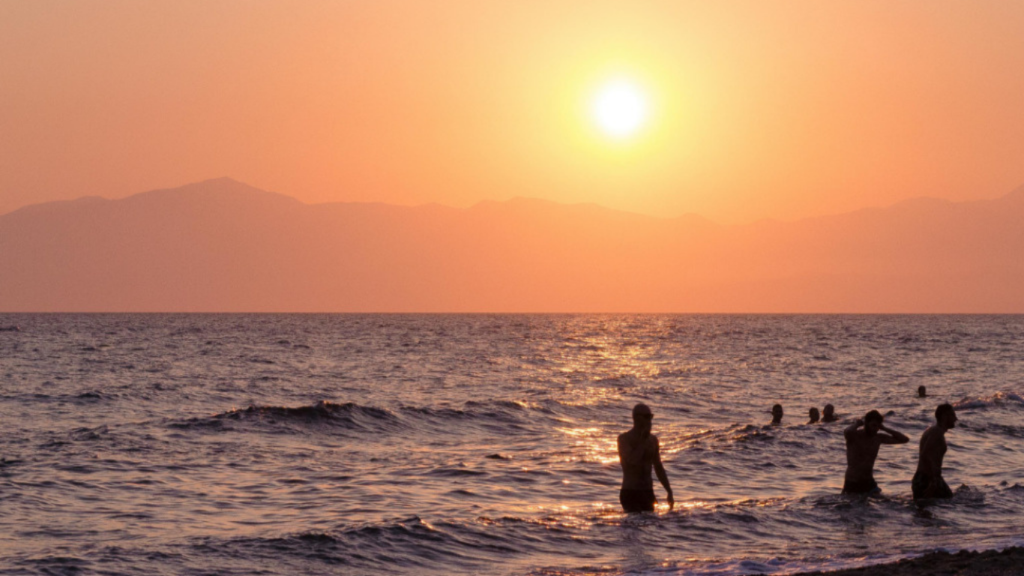 Sunset at Calangute Beach with people standing near the shoreline